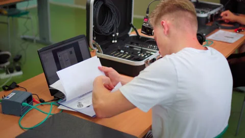 Male Apprentice Looking On Printed Modules In Trade School With Instructor Stock Footage 211795962