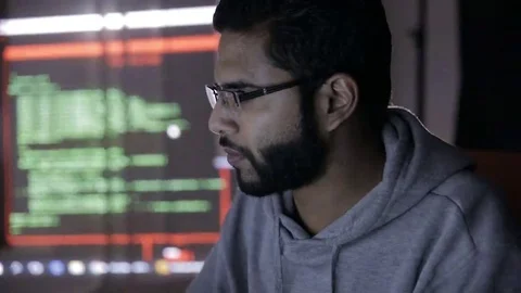 Male arabic hacker hacks computer in dark. Computer code reflecting on his face 스톡 동영상 69207578