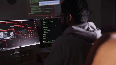 Male arabic hacker hacks computer in dark. Computer code reflecting on his face 스톡 동영상 69207770