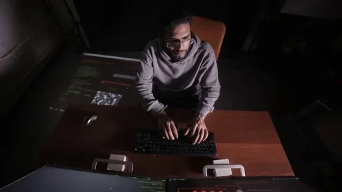 Male arabic hacker hacks computer in dark. Computer code reflecting on his face 스톡 동영상 69208738