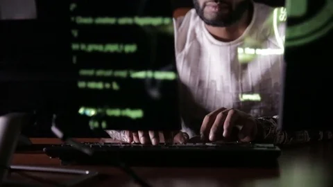 Male arabic hacker hacks computer in dark. Computer code reflecting on his face 스톡 동영상 71583961
