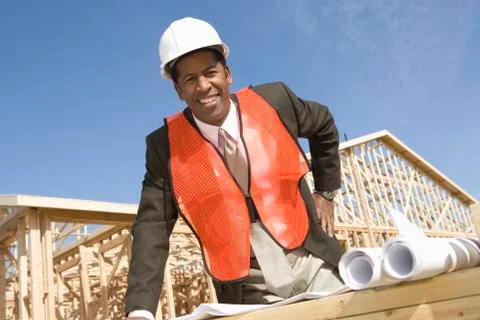 Male Architect Standing In Front Of Framework With Blueprint Stock Photos