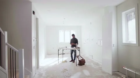 Male architect working t table at new house under construction Stock Footage 221041409