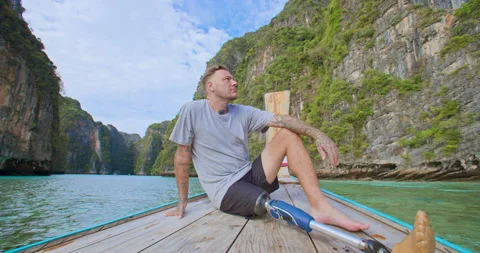 Male with artificial bionic leg sitting on boat front seeing beautiful seascape. Stock Footage 195002533