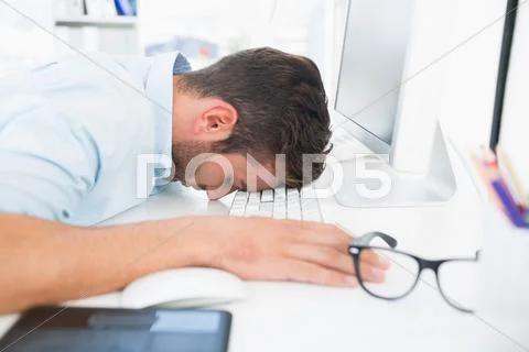 Male artist with head resting on keyboard Stock Photos
