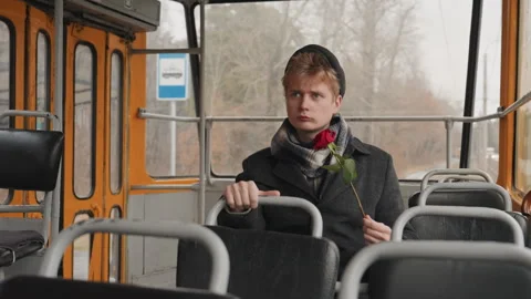 Male artist reflects on affection during cloudy city transit ride. Musician Stock Footage 332926537