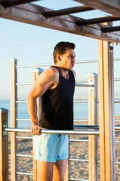 Male athlete doing dips on parallel bars Stock Photos