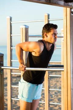Male athlete doing dips on parallel bars 스톡 사진