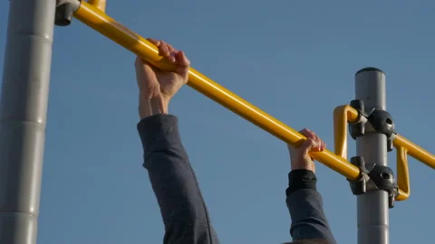 Male athlete doing exercise on horizontal bar outdoors Stock Footage 149998468