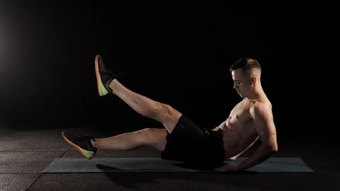 Male athlete doing flutter kicks in the gym. Stock Footage 93591963
