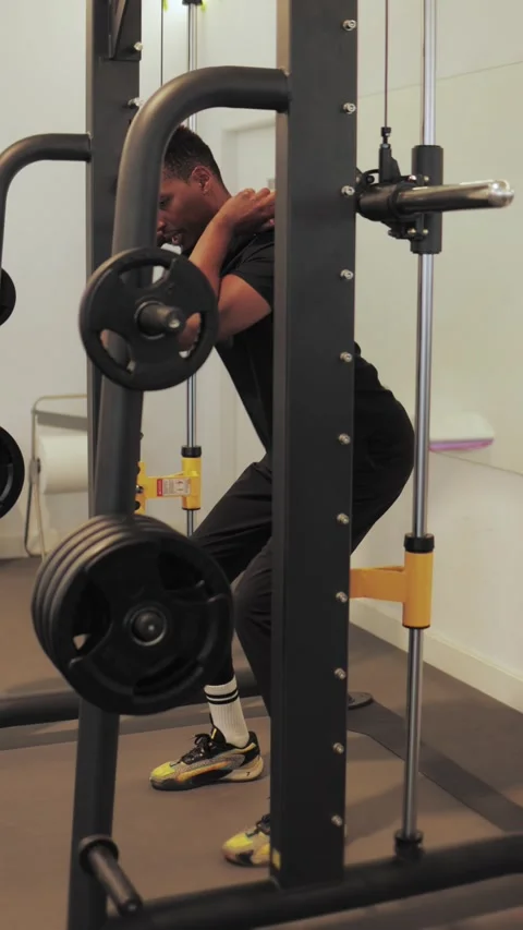 Male athlete executing precise smith machine squats with strength and dedic.. Stock Footage 309546862