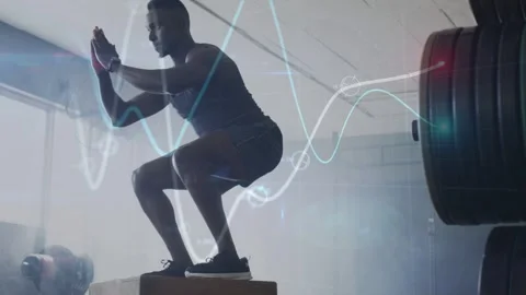 Male athlete lowering into squat, jumping onto plyo box in gym with waveform Stock Footage 334883723