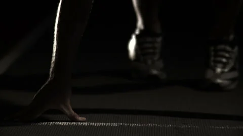 A male athlete runner gets himself set at the starting line of a track Stock Footage 33834465