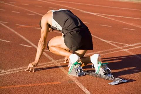Male athlete in starting blocks on a running track Stock Photos