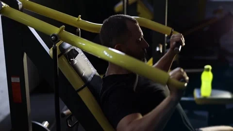 Male athlete using exercise machine during strength training in gym. Stock Footage 313789175