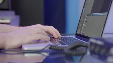Male audio engineer hands type on keyboard laptop while working on an Stock Footage 257470592