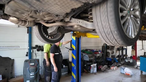 Male auto mechanics doing technical inspection and diagnostic of vehicle Stock Footage 303617416
