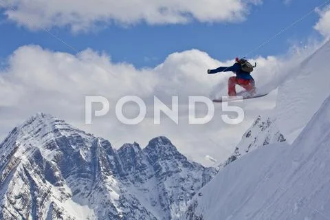 A Male Backcountry Snowboarder Airs A Pillow With Classic Canadian Rockies