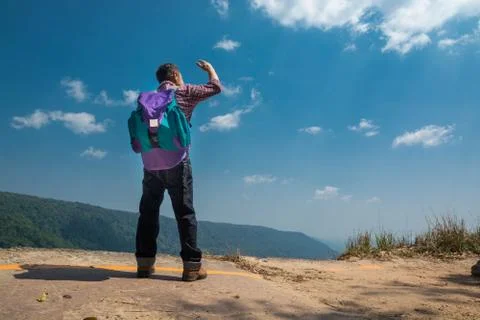Male Backpacker Stand on cliff while Travel Trekking Trip over Green Nature M Stock Photos