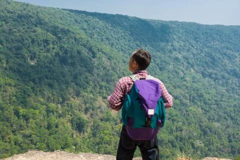 Male Backpacker Stand on cliff while Travel Trekking Trip over Green Nature M Stock Photos