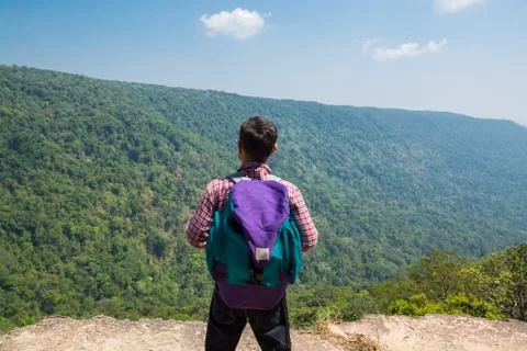 Male Backpacker Stand on cliff while Travel Trekking Trip over Green Nature M Stock Photos