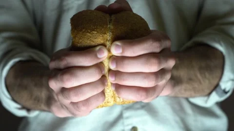 A male baker is breaking open rye buns. Close-up. Stock Footage 131515727