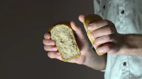 A male baker is breaking open rye buns. Close-up. Stock Footage 131516555