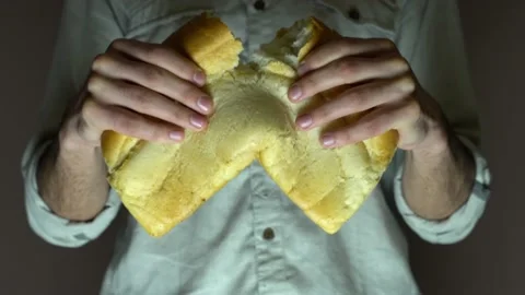Male baker breaks white bread into two parts. Close-up. Stock Footage 131516087