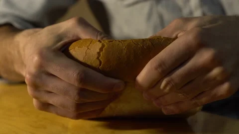 Male baker breaks white bread into two parts. Close-up. Stock Footage 131517204