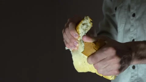 Male baker breaks white bread into two parts. Close-up. Stock Footage 131517545