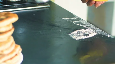 Male baker is cleaning kitchen table from flour after cooking Stock Footage 108852839