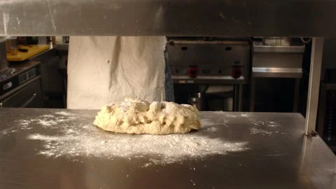Male baker kneading dough on kitchen table Video stock 238638397
