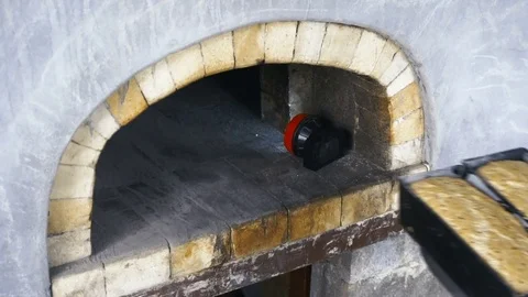 Male Baker Putting Bread into Brick Oven for Baking Stock Footage 77603608