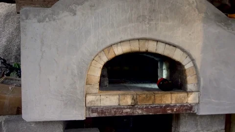 Male Baker Putting Bread into Brick Oven for Baking Stock Footage 77604232