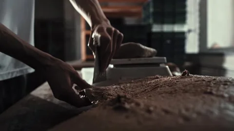 Male baker using scraper to divide large mass of dough into smaller portions Stock Footage 342230382