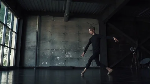 Male ballet dancer dancing classical ballet in a dark studio. slow motion Stock Footage 94124446