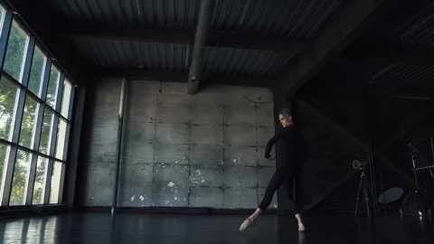 Male ballet dancer dancing classical ballet in a dark studio. Stock Footage 94138898