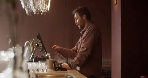 Male bar owner using computer at counter Stock Footage 239167129