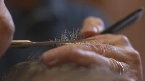 MALE BARBER CUTTING HAIR OF MALE CLIENT WITH SCISSORS AND COMB Stock Footage