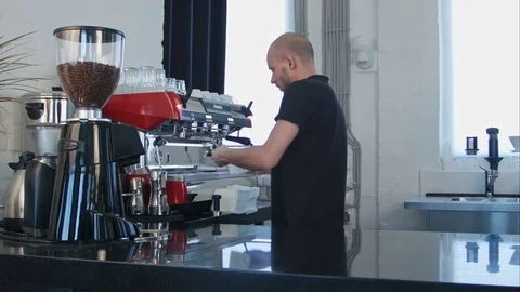 Male barista using the coffee machine preparing coffee for a client Vídeos de archivo 77422750