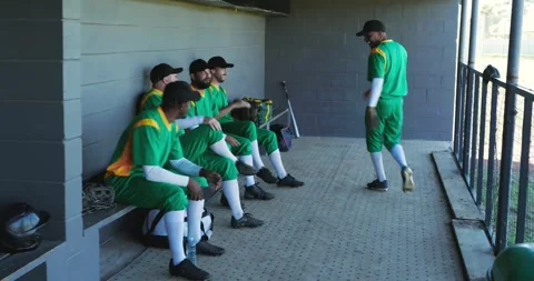 Male baseball player walking into dugout high-fiving teammates showing glove, Stock Footage 342926327