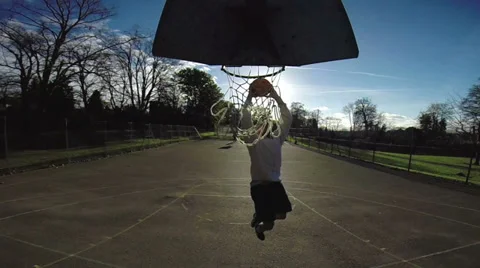 Male basketball player slam dunking in slow motion Stock Footage