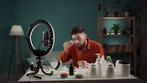 Male beautician making make up tutorial on mobile phone at home. Man is applying Video stock 255794591
