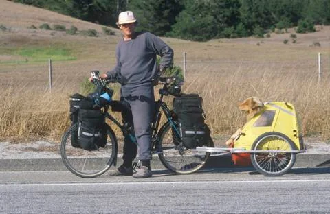 Male bicyclist posing with dog in carrier on Pacific Coast Highway, CA Stock Photos