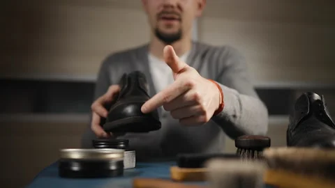 Male blogger live streaming tutorial how to clean and care for shoes Stock Footage 145256309