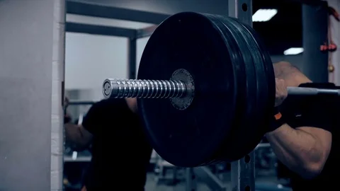 Male bodybuilder doing squats with a barbell at the gym Stock Footage 70453033