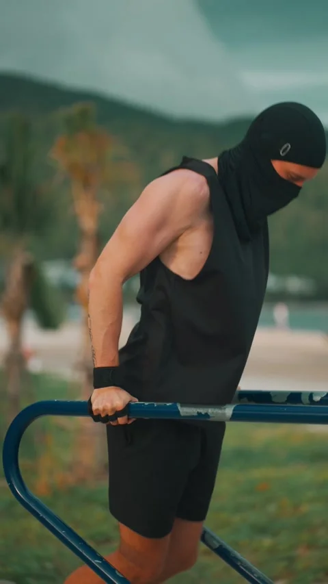 Male bodybuilder performing dips on parallel bars during sunset workout, Athlete Stock Footage 314164099