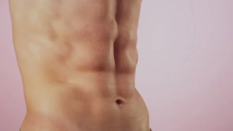 Male bodybuilder poses in studio demonstrating results of training in gym and Stock Footage 163873205