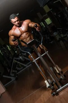 Male bodybuilder using the elliptical machine Stock Photos