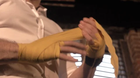 Male boxing trainer wrap protective sports tape around his arm Stock Footage 112940428